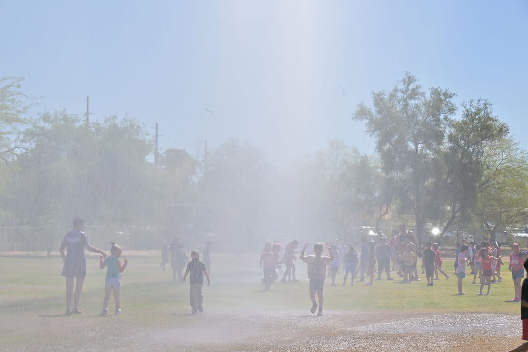 Students run around in the spray of water