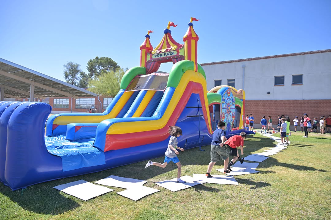 Students run around a colorful bouncy castle and slide