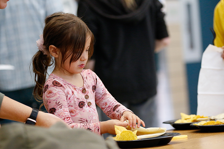 A girl folds up her tortilla